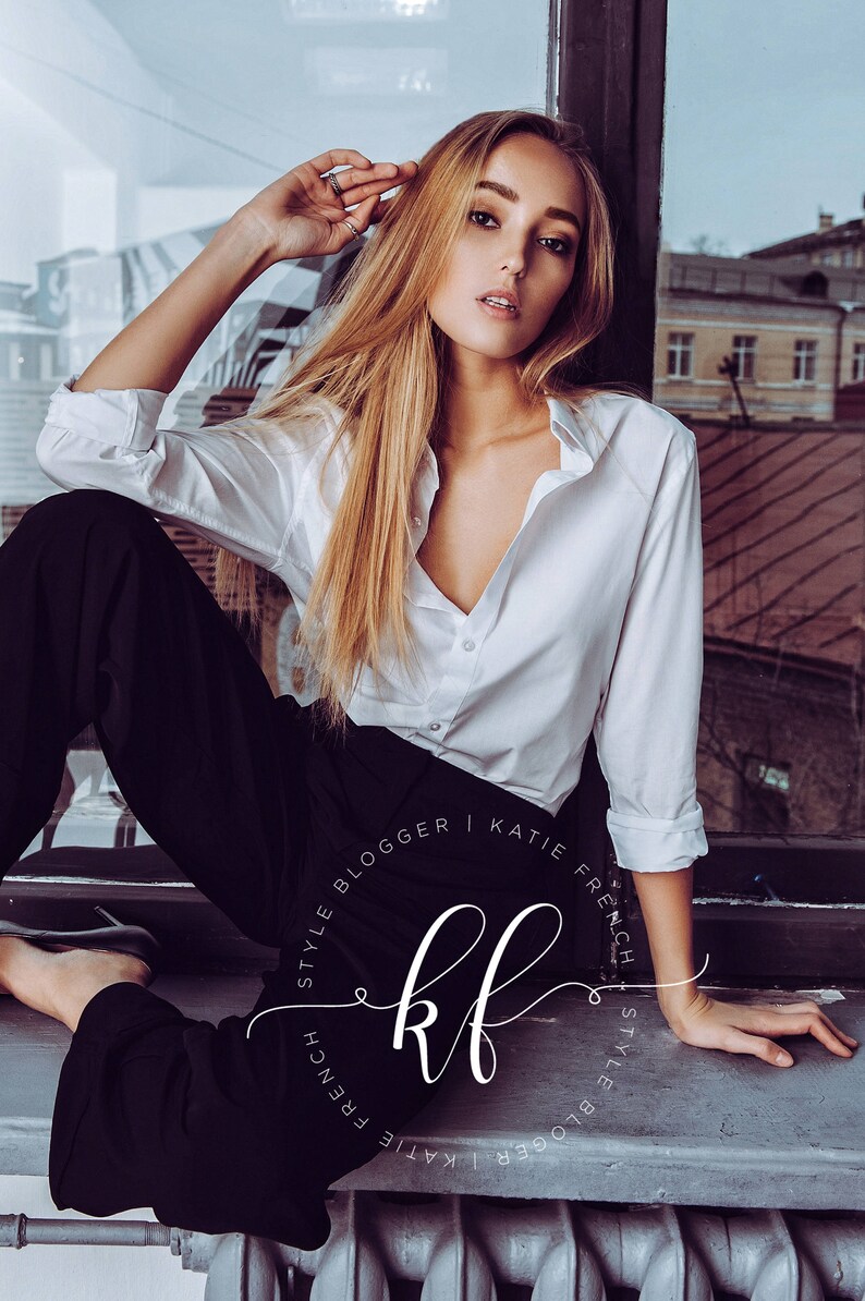 May include: A woman wearing a white button-down shirt and black trousers sits by a window. The text "Style Blogger | Katie French | Style Blogger" is written in a circle around the letters "kf".