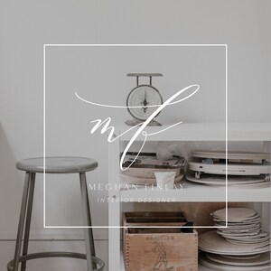 May include: A white shelving unit with a vintage scale, a wooden box labelled "Hercules Powder", and stacks of ceramic plates. The shelving unit is in a white room with a grey stool.