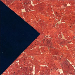 May include: A piece of fabric featuring a triangular section of solid black material contrasted against a larger section of red cork material with a natural, multi-faceted, and speckled texture throughout the surface.