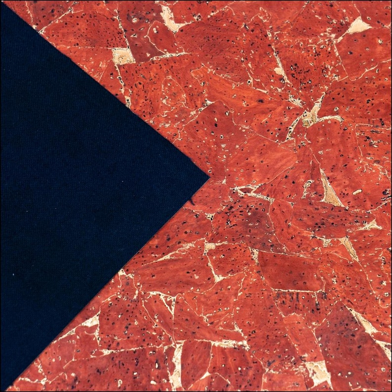 May include: A piece of fabric featuring a triangular section of solid black material contrasted against a larger section of red cork material with a natural, multi-faceted, and speckled texture throughout the surface.