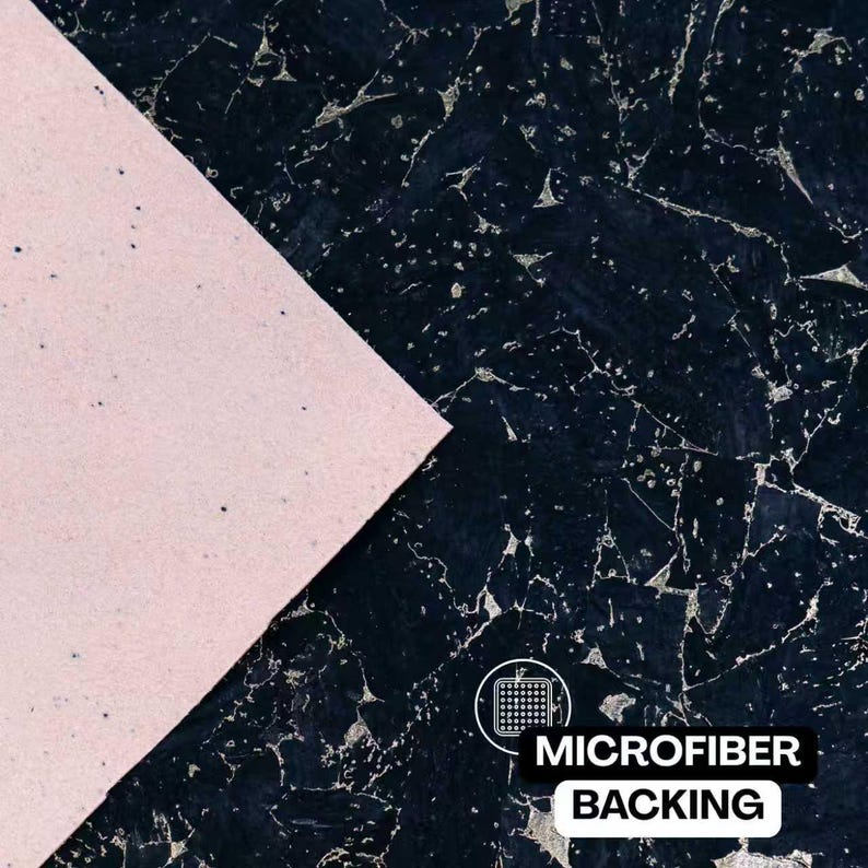 May include: A sheet of material featuring a dark navy blue surface with a textured, fragmented pattern and silver-toned veining, partially overlaid by a smooth, light pink triangular section. Text reads MICROFIBER BACKING.