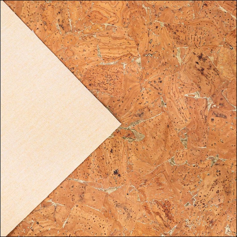 May include: A diagonal view of a cork surface with a light beige fabric corner. The cork has a natural, textured appearance with varying shades of brown and gold. The fabric corner is smooth and light-colored.