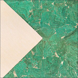 May include: A sheet of green cork fabric with a textured, multi-tonal mosaic pattern featuring irregular shapes and dark flecks, partially overlaid by a triangular section of plain, light beige fabric with a visible woven texture.