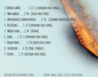 May include: A wooden kantele, a traditional Finnish stringed instrument, with a light brown finish and intricate carvings. The kantele is lying on a light blue surface with a white background. The image includes a list of songs and their durations, along with the instruments used in the recording.