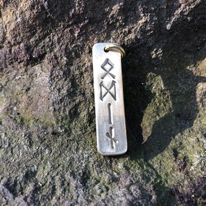 May include: A silver-colored metal keychain with a rectangular tag engraved with a series of runes.