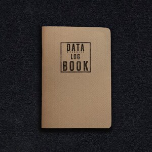 May include: A brown notebook with the text "DATA WRANGLER LOG BOOK" printed on the front cover.
