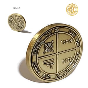 May include: A gold-colored metal coin with four sections, each containing Hebrew text and symbols. The coin is inscribed with the words "King Solomon" and a crown.