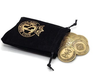 May include: A black velvet pouch with gold lettering that reads "King Solomon Coin" and contains a set of seven gold-colored coins with intricate designs.
