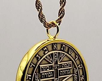 May include: A gold chain necklace with a round pendant featuring Hebrew lettering and a geometric design. The pendant is surrounded by a circle of Hebrew letters.