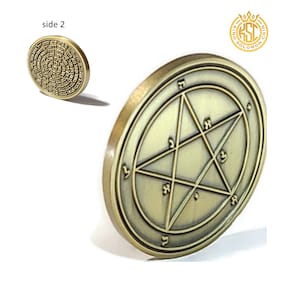 May include: A gold-colored coin with a five-pointed star inscribed with Hebrew characters on one side and a circle of Hebrew characters on the other side. The coin is labeled "King Solomon Coin".