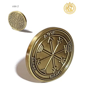 May include: A gold-colored metal coin with a circular design. The front side features a starburst with Hebrew text around the edge. The back side features a circular design with Hebrew text.