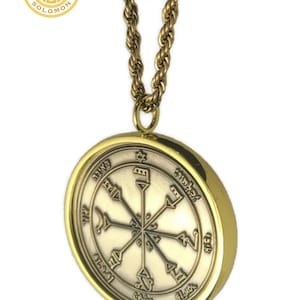 May include: A gold chain necklace with a round pendant featuring a silver seal with Hebrew text and symbols. The pendant is surrounded by a gold rim.