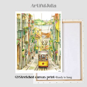 Puede incluir: Una pintura de acuarela de un tranv&iacute;a amarillo que viaja por una calle estrecha en Lisboa, Portugal. La calle est&aacute; bordeada de edificios coloridos y vegetaci&oacute;n exuberante. La pintura est&aacute; sobre un lienzo estirado, lista para colgar.