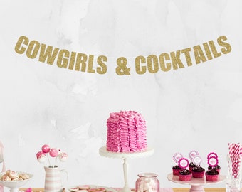 May include: A pink and gold party table setting with a cake, cupcakes, and cookies. The table is decorated with a gold glitter banner that reads "COWGIRLS & COCKTAILS".
