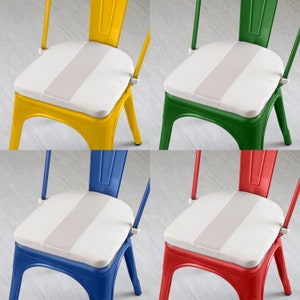May include: Four colorful metal chairs: yellow, green, blue, and red. Each chair has a white seat cushion with a light gray stripe down the center. The chairs have a classic industrial design.