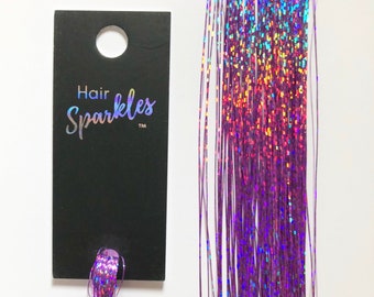 May include: Purple iridescent hair tinsel strands with a black card that says "Hair Sparkles TM".