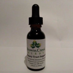 Könnte beinhalten: Eine braune Glasflasche mit Tropfer, beschriftet mit "Browns Creek Herbs Urinary Tract Support". Das Etikett listet auch die Zutaten auf, darunter Schafgarbe, Echinacea, Brennnessel, Löwenzahnblatt und Goldsiegel. Es enthält nicht-GVO-Alkohol und ist 1 Flüssigunze (30 ml) groß.