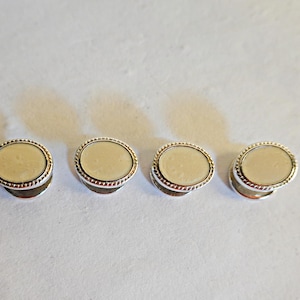 May include: Four silver and white oval cufflinks with a beaded edge.