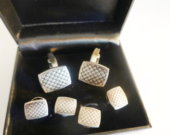 May include: A set of five silver cufflinks in a black box. The cufflinks have a geometric pattern.
