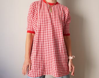 May include: A red and white gingham oversized shirt with red trim on the sleeves. The shirt has a relaxed fit and is made of a lightweight fabric.
