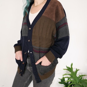 May include: A multi-coloured cardigan with a brown suede panel, blue, green and red knit patterns, and a button closure.