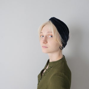 Puede incluir: Una persona con cabello rubio que lleva una diadema de terciopelo azul oscuro y una camisa verde con cuello.