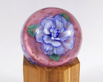 Hand-made glass marble blue flower made from uranium glass with pink and gold background