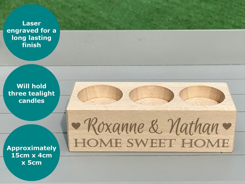 May include: A wooden candle holder with three tealight candle wells. The holder is engraved with the text "Roxanne & Nathan HOME SWEET HOME" and two hearts.