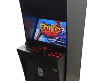May include: A black arcade machine with a screen displaying a video game. The machine has red buttons and joysticks for gameplay. The top section has a light. The game on the screen is titled "Street Hoop".