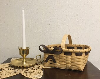 Cesta artesanal con acabado en roble y detalles en marrón.