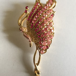 Broche papillon dorée en faux cristaux roses....
