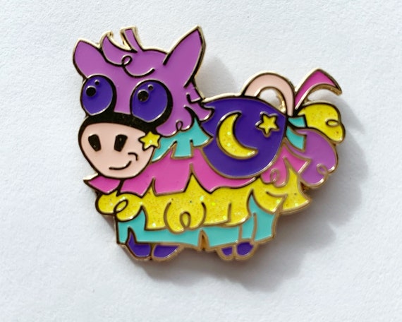 Candi the Piñata hard enamel pin original character design with glitter accents, 1.5” wide in lively pastels. Collect pins, collect art!