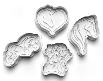 Könnte beinhalten: Vier weiße Ausstecher in Pferdeform aus Kunststoff. Die Designs umfassen einen Pferdekopf in einem Herzen, ein Pferdeprofil und zwei weitere Pferdefiguren. Ideal für die Herstellung von Keksen oder Fondantdekorationen mit Pferdemotiven.