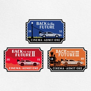 May include: Three rectangular tickets with a black border and the words "Back to the Future" in white. Each ticket features a DeLorean car and the words "Cinema Admit One". The tickets are blue, red, and orange.
