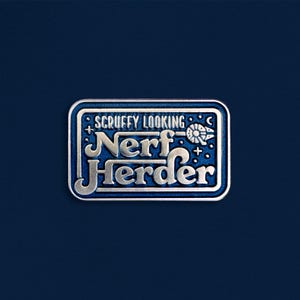 May include: A rectangular metal enamel pin with a dark blue background and silver raised lettering that reads SCRUFFY LOOKING NERF HERDER. The design includes a small silver spaceship icon, stars, and a thin silver border surrounding the text.