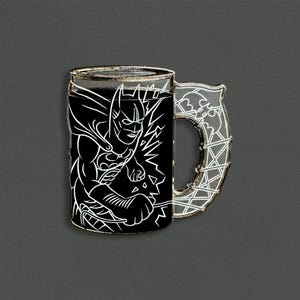 May include: A Batman-themed mug pin with a black background and a white outline of Batman. The handle is a clear, silver-colored design with a bat symbol. The mug is a unique collectible item.
