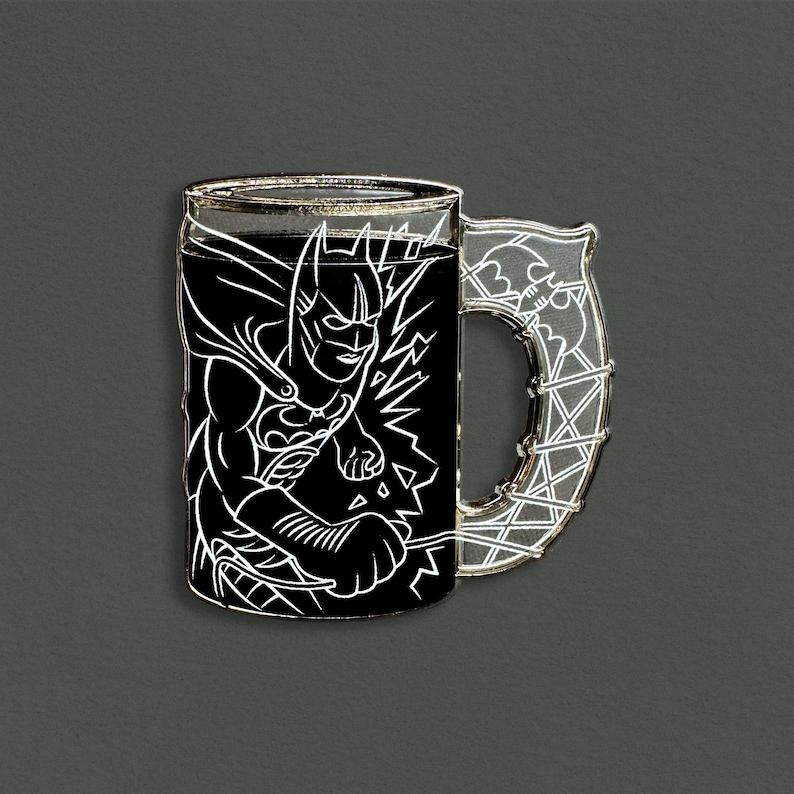 May include: A Batman-themed mug pin with a black background and a white outline of Batman. The handle is a clear, silver-colored design with a bat symbol. The mug is a unique collectible item.
