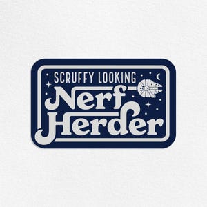 May include: A navy blue sticker with white text and a stylized spaceship illustration. The text reads "Scruffy Looking Nerf Herder" in a vintage, rounded font. The design includes stars and a crescent moon.