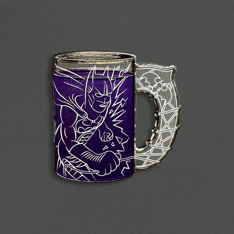 May include: A Batman-themed mug pin with a purple liquid effect. The white outline of Batman is featured on the front of the mug. The handle is silver with a web-like design. The mug has a silver rim.