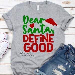 May include: Gray t-shirt with the text "Dear Santa, Define Good" in green and red lettering. A red Santa hat is above the word "Santa". The text "My Designs in the Chaos" is below the main text.
