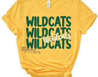 May include: Yellow t-shirt with the text "Wildcats" repeated three times in green and once in yellow. The text "My Designs in the Chaos" is printed in black below the word "Wildcats".