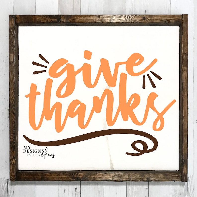May include: A white sign with a brown wooden frame, featuring the text "give thanks" in orange lettering with a brown swirl design underneath. The text "My Designs in the Chaos" is in the bottom left corner.