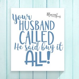 May include: White sign with blue text that reads "Your husband called. He said buy it all!" The text is in a handwritten style font.