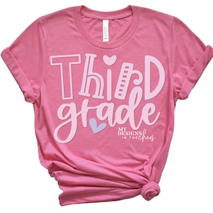 May include: Pink t-shirt with the text "Third grade" in pink with a heart design. The text "My Designs in the Chaos" is in smaller text below.
