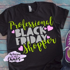 May include: Black t-shirt with the text "Professional Black Friday Shopper" in green and gray lettering with pink hearts. The text "My Designs in the Chaos" is in a purple watercolor design.
