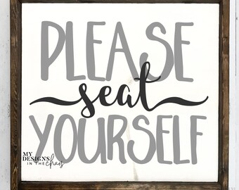 Puede incluir: Un cartel blanco con un marco de madera marrón. El cartel dice "PLEASE seat YOURSELF" en letras grises y negras.