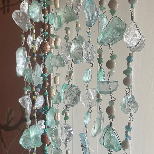 18” Teal/ sea foam colored strand (one strand) Sea Glass strung w/ accentuating shell beads. Hung from swivel hook.