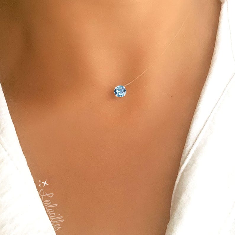 Pode incluir: Um colar delicado e transparente com um &uacute;nico pingente de cristal azul claro.