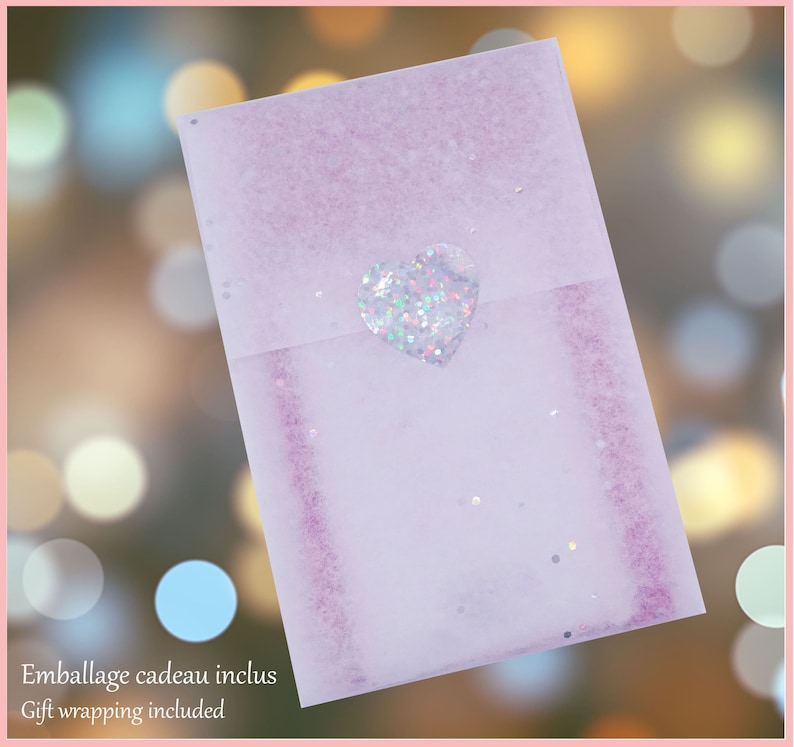 May include: A lavender gift envelope with a glittery heart-shaped sticker. The envelope has a textured appearance and is decorated with small, sparkling accents. Text on the bottom reads "Gift wrapping included."