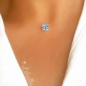 Pode incluir: Um colar delicado e transparente com um pingente de pedra preciosa azul claro. O colar &eacute; feito de um fio fino invis&iacute;vel e &eacute; perfeito para o uso di&aacute;rio.